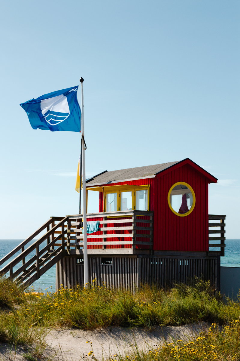 Lifeguard hut with blue flag blowing in the wind